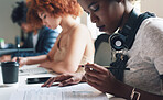 A diverse group of students reading paperwork and studying. A young student reading her academic texts before making notes. A serious academic student reading through her reports while studying