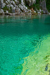 Beautiful nature landscape of a blue river flowing though an exotic evergreen travel destination. Clear water of a lake on a summer day