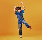 One cute mixed race child wearing casual clothes while having fun and being energetic against an orange copyspace background. Asian kid being active