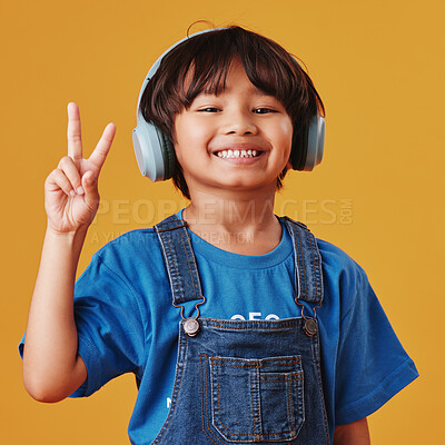 Buy stock photo Asian boy, portrait and headphones with sound, peace sign and happiness on yellow studio background. Review audio, radio or model with headset, support and smile with tech, child friendly and emoji