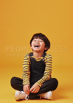 Buy stock photo Laughing, portrait and smile of Asian boy on yellow background, isolated in studio for child development. Comedy, funny or silly and excited kid on mockup space for emotions, fashion or growth