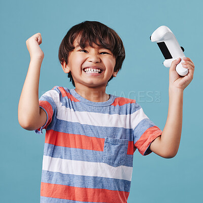 Buy stock photo Boy, controller and gamer portrait for celebration in studio, winner and esports success or triumph. Male person, child and console for playing on blue background, arcade competition and achievement