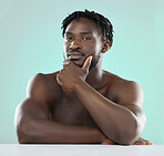 Confident, handsome and portrait of a young black man isolated on a blue background in studio. Sexy, skincare and healthy body of an African model with muscle, confidence and seduction on a backdrop