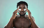 Skincare, eye pads and black man in studio for healthy, cosmetic and natural face routine. Health, wellness and portrait of an African guy with a facial treatment by blue background with mockup space