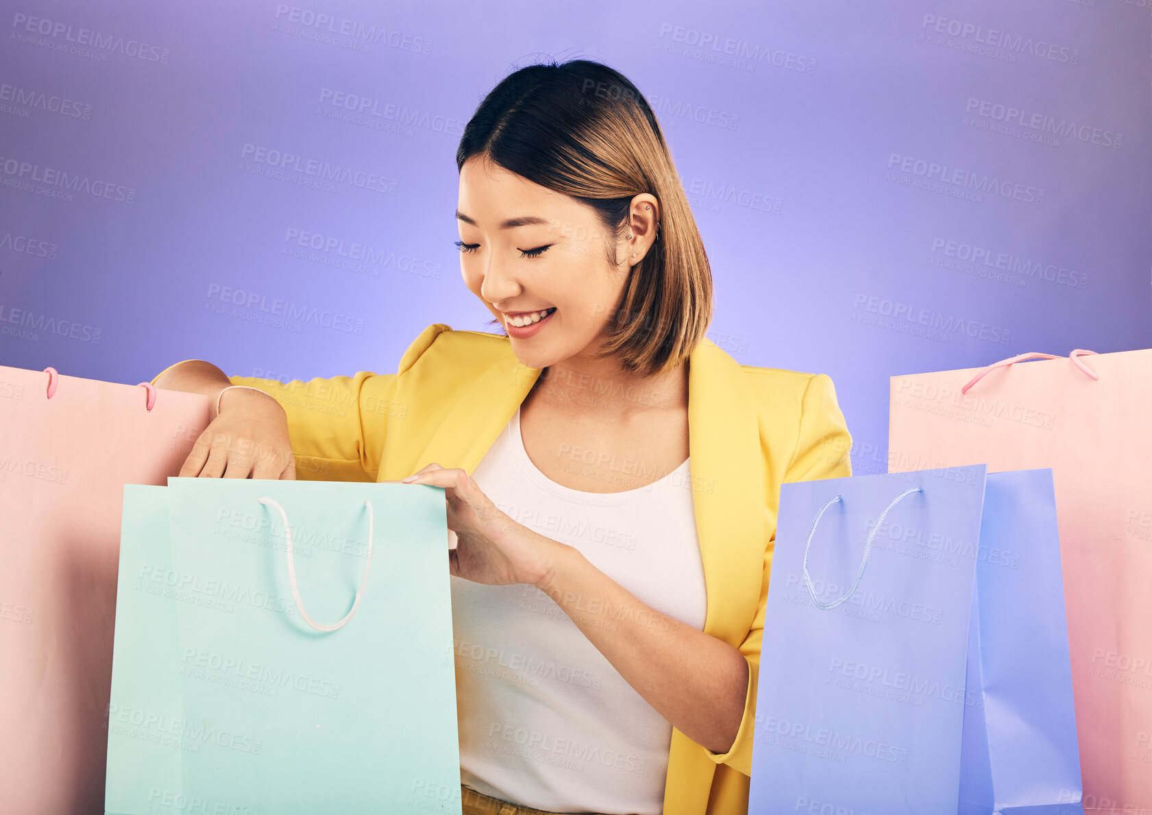 Buy stock photo Check, shopping bag and happy woman for fashion sale, discount or retail prize on studio, purple background. Happy young model, asian person or customer with choice, giveaway and rich, wealth or gift