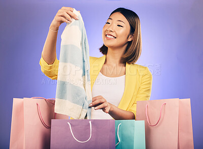 Buy stock photo Fashion, shopping bag and happy woman with product sale, discount or promotion on a studio, purple background. Excited young model, asian person or customer clothes choice, retail and e commerce gift