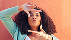 Happy model, funny frame face on wall background and portrait smile in sunshine. Young african woman laugh at focus gesture, ready for closeup and crazy creative photography idea with afro