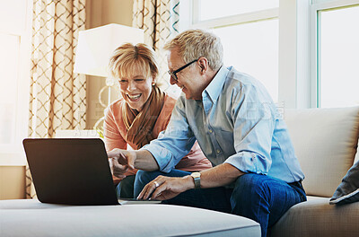 Buy stock photo Shot of a mature couple using a laptop together at home on the sofa