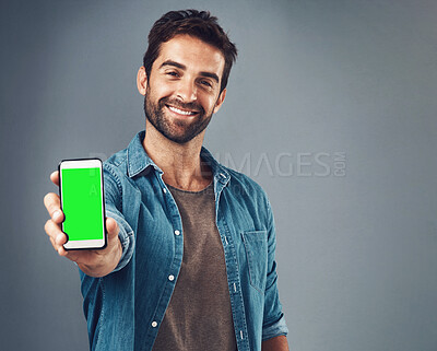 Buy stock photo Happy man, phone and mockup green screen for advertising or marketing against a grey studio background. Portrait of male person smiling and showing smartphone display or chromakey for advertisement