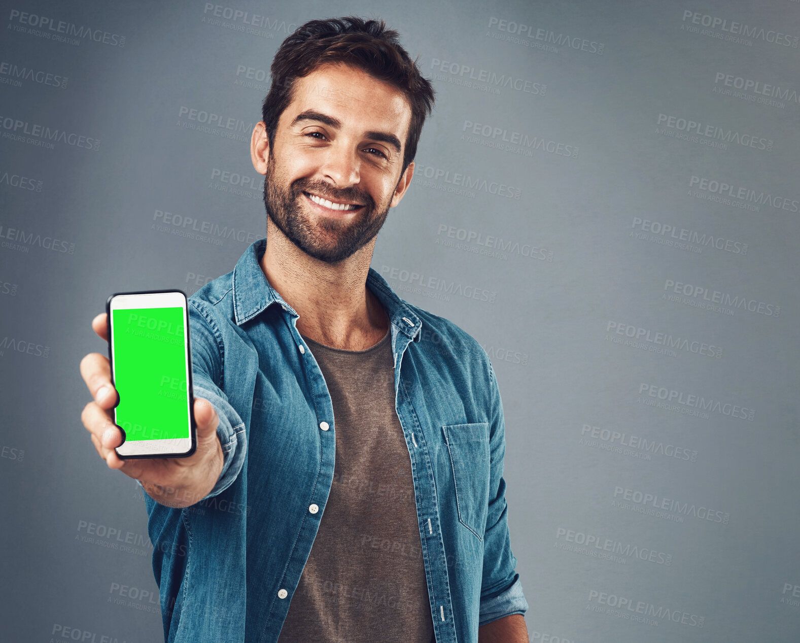 Buy stock photo Happy man, phone and mockup green screen for advertising or marketing against a grey studio background. Portrait of male person smiling and showing smartphone display or chromakey for advertisement