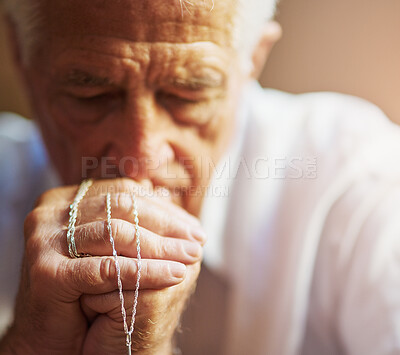 Buy stock photo Cropped shot of a senior man holding a rosary while praying for a miracle