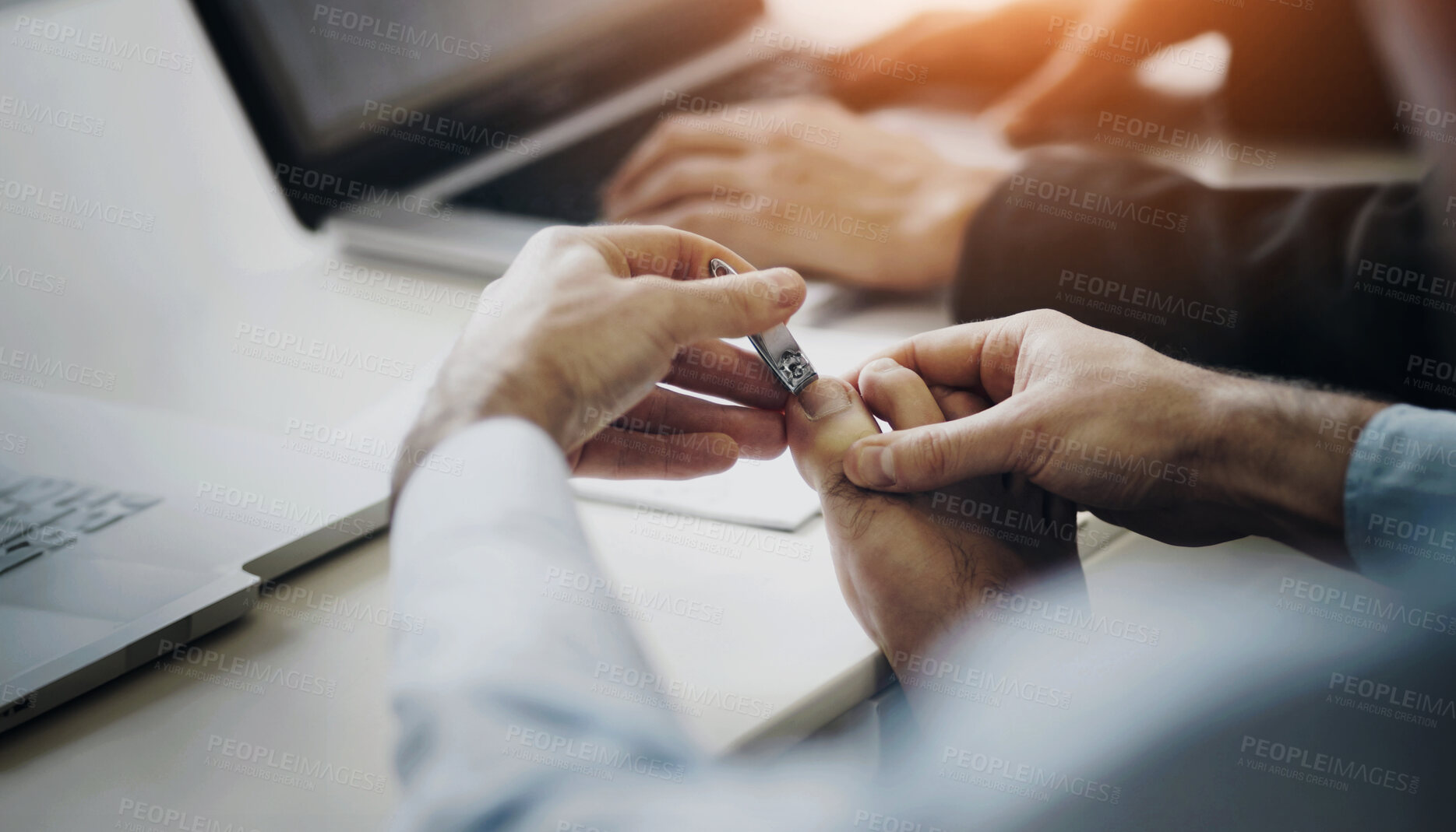 Buy stock photo A young man clipping his toenails on his desk at work