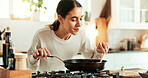 Female person, aroma and cooking as chef in kitchen for diet or recipe in home for satisfaction. Woman, frying pan and gourmet cuisine as creative or nutritionist for meal preparation, dinner or food