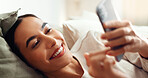 Woman, phone and relax on bed with social media, entertainment and dating app for networking. Female person, home surfing and reading romance ebook on website, communication and chilling in bedroom