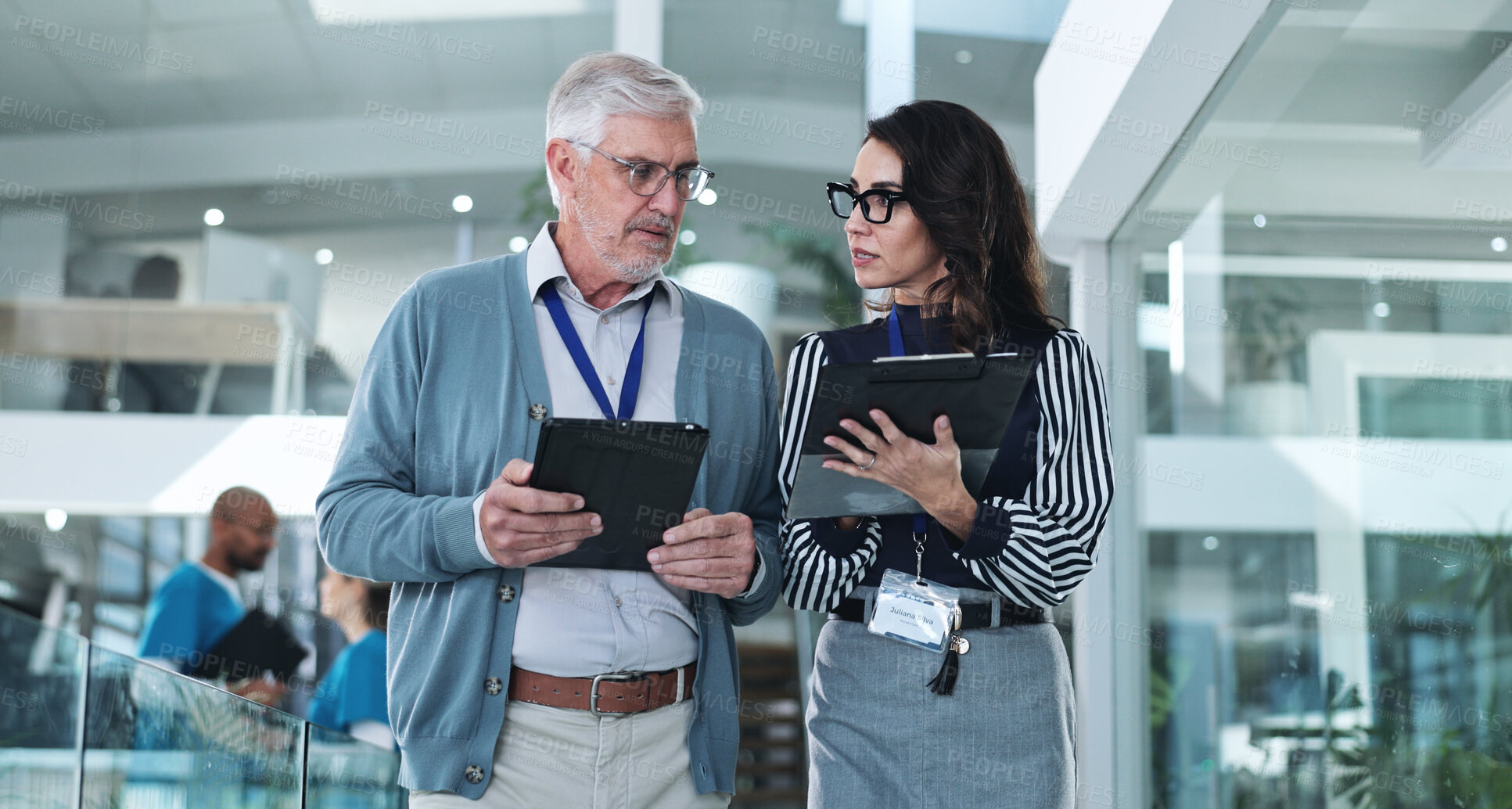 Buy stock photo Man, woman or tablet in hospital for meeting, innovation or feedback for clinic development. Mature executive, assistant or tech in lobby for discussion, advice or professional opinion for healthcare