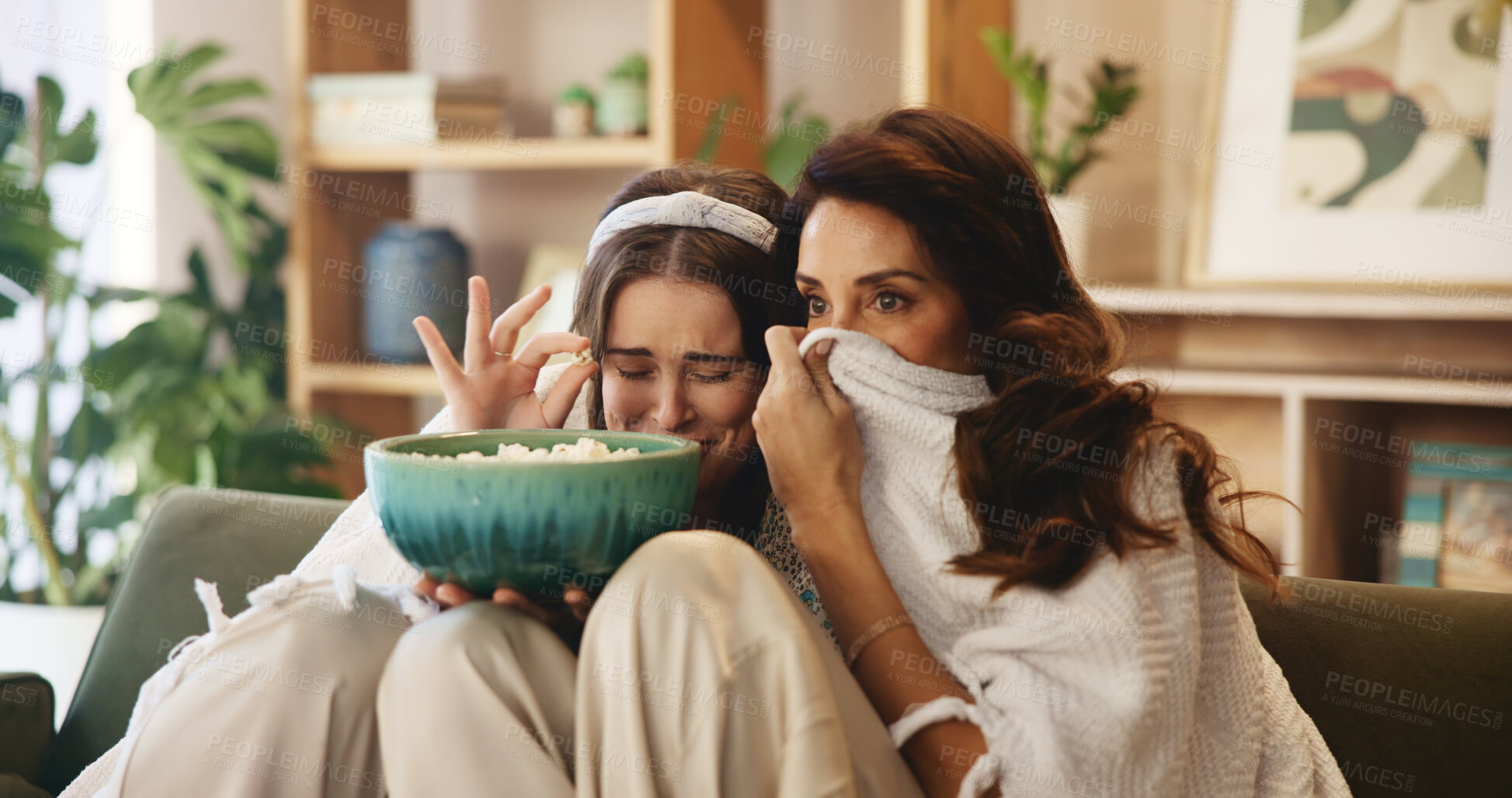 Buy stock photo Popcorn, mature mother and scared daughter on sofa with bonding, fear and watching tv in living room. Weekend, snacks and mom on couch with girl for movie, television show and horror in home together