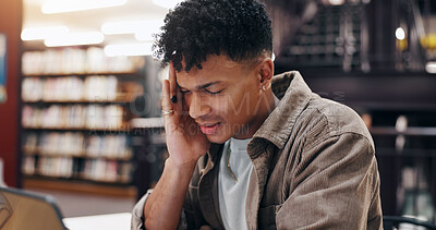 Buy stock photo Man, student and tech in library with headache, stress and massage temple for relief. Person, laptop and migraine at university campus with fatigue, tension and tired with research or assignment