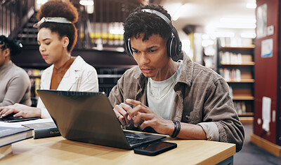 Buy stock photo Man, studying or laptop in library with headphones, problem solving or working on research assignment. Student group, concentration music or tech at college for education, online course or learning