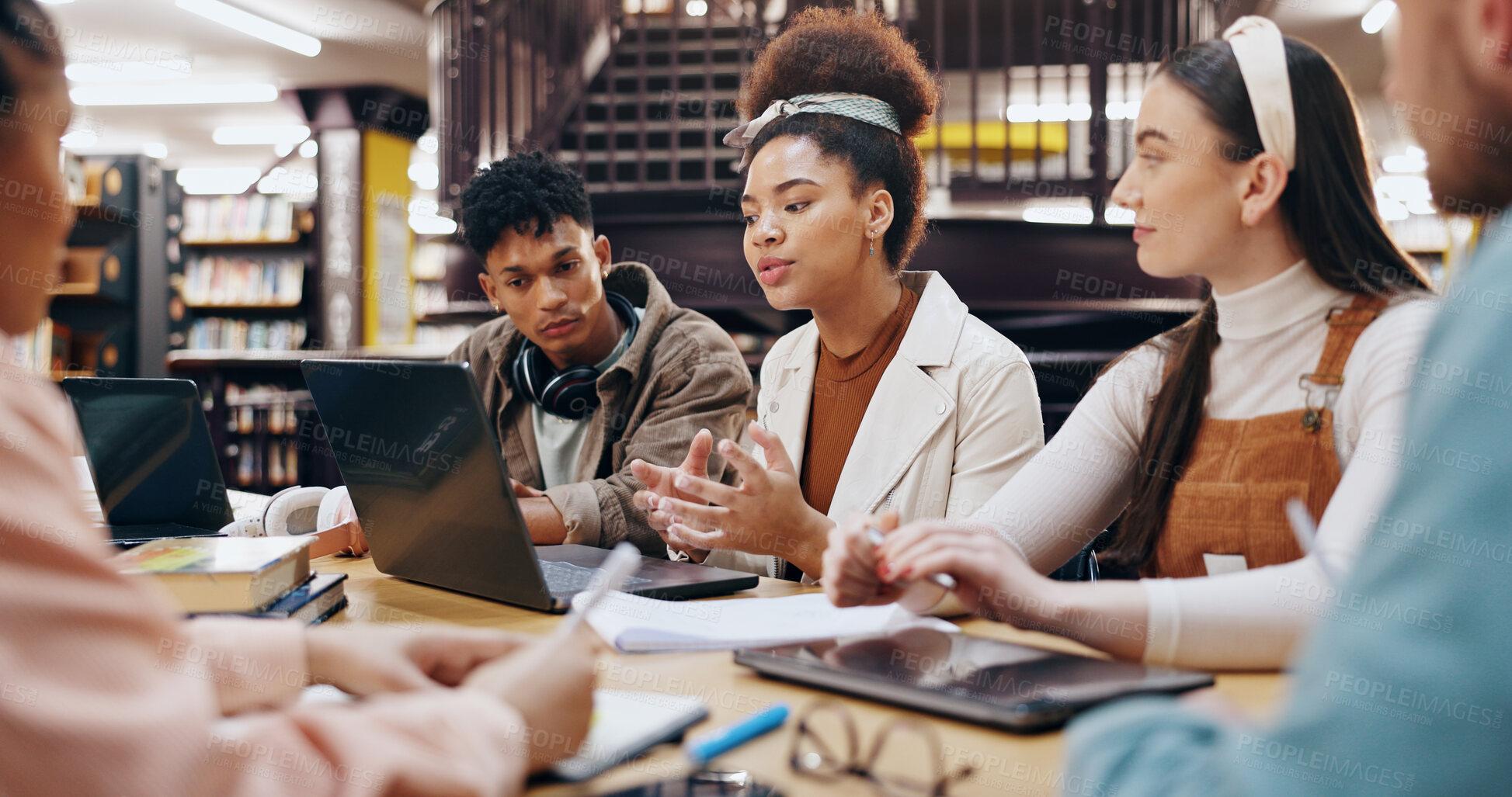 Buy stock photo People, students and laptop in library for discussion, planning and working on research assignment. Study group, exam preparation or tech at university for education, collaboration or course feedback