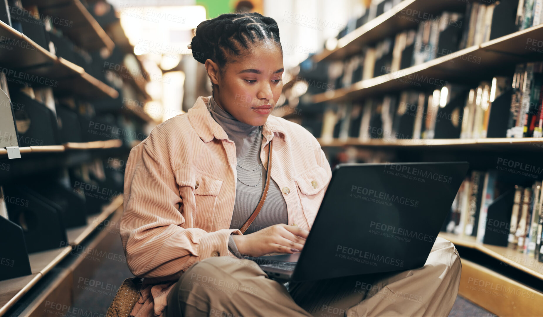 Buy stock photo African, woman and student with laptop in library for research information, university news and study schedule. Girl, digital and reading online with education ebook, exam results and project report