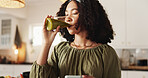 Woman, home and drinking with green smoothie on glass for health, nutrition and diet. Female person, nutritionist and satisfied at kitchen with juice for supplements, detox and vitamins for wellbeing