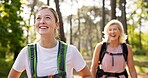 Mother, daughter and walking in forest with laughing for fitness adventure, sightseeing and explore nature. Backpack, mature woman and girl in woods with hiking, holiday travel and bonding with joke