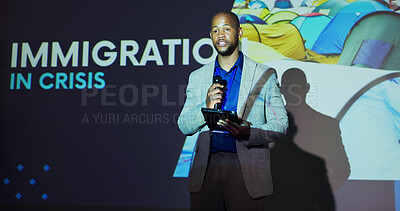 Buy stock photo Seminar, presenter and black man at screen for global immigration presentation with microphone, tablet and ideas. Information, change and speaker on stage for conference on world refugee crisis forum