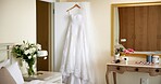 Wedding, room and dress for event, empty and elegant for marriage, fashion and style in morning and bridal. Glamour, outfit and clothes on hanger, preparation and ceremony in resort and flowers