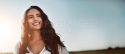 Buy stock photo Shot of an attractive young woman standing outside in a field