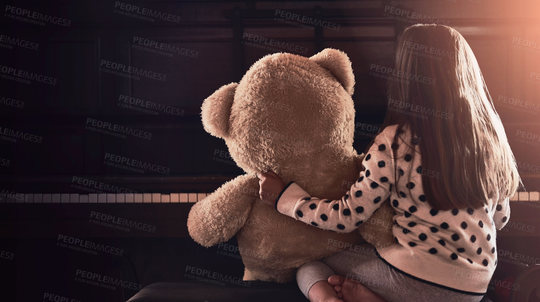 Buy stock photo Rear view shot of a little girl sitting in front of a piano with her teddy bear