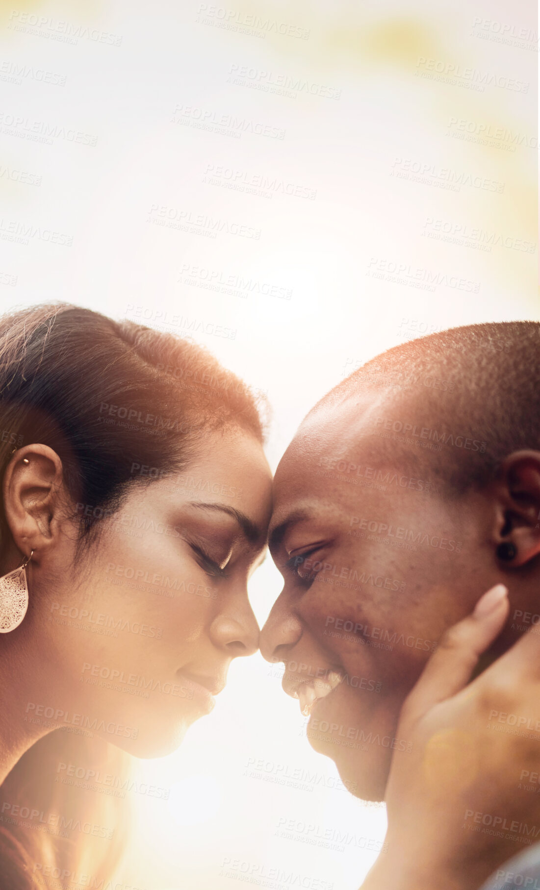 Buy stock photo Shot of an affectionate young couple sharing a tender moment outdoors