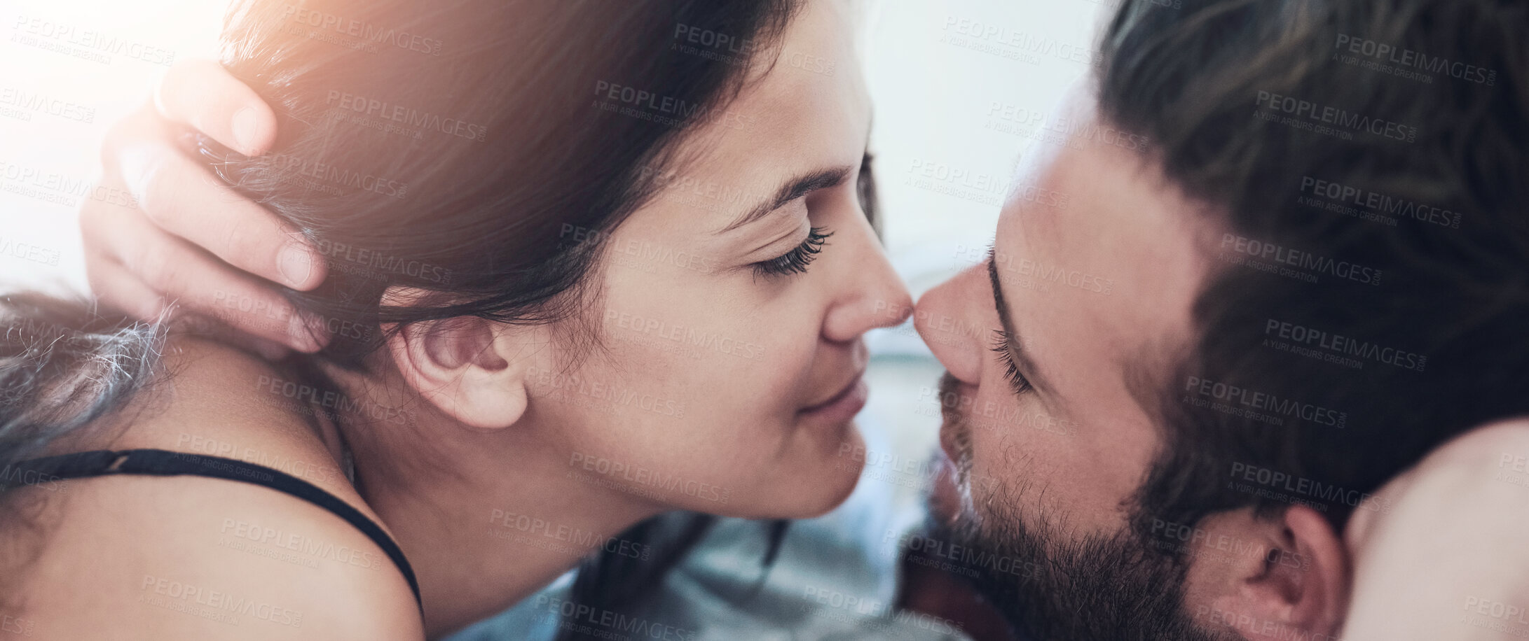 Buy stock photo Shot of an affectionate couple lying on their bed