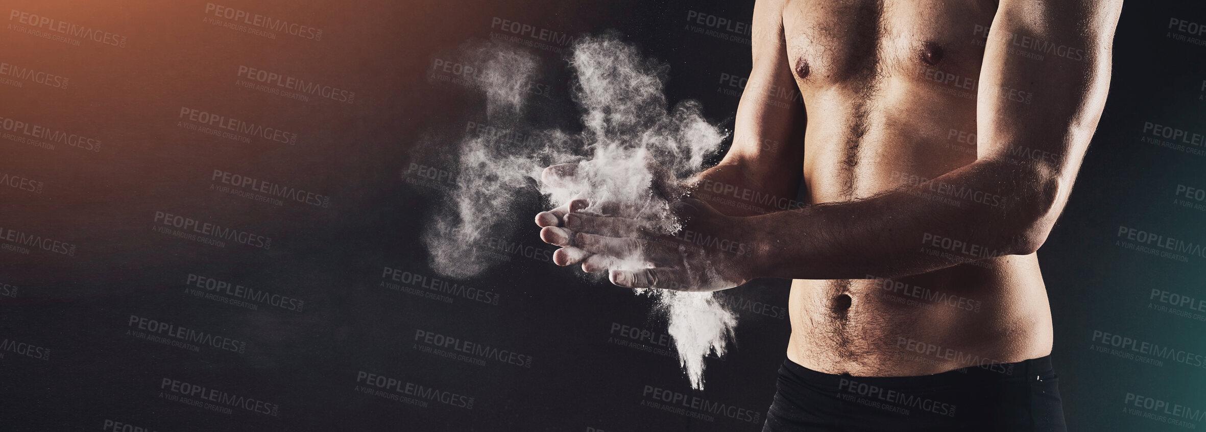 Buy stock photo Shot of a man's torso while applying talc powder to his hands against a dark background