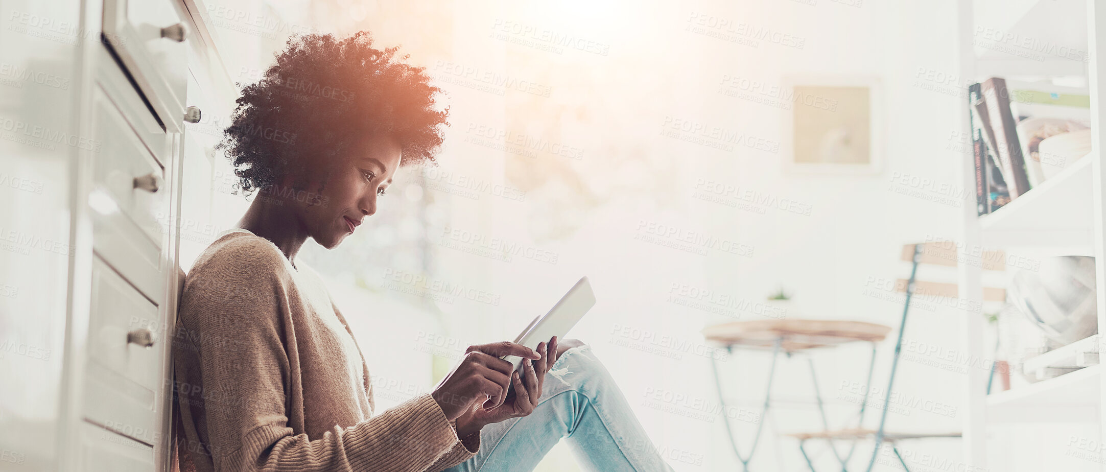 Buy stock photo Shot of a young woman using a digital tablet at home