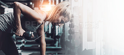 Buy stock photo Shot of a sporty woman working out on her own in the gym