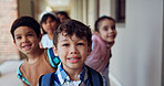 Hallway, portrait and boy with students, classroom and education with happiness, smile and learning. Lobby, face and kids with knowledge, child development and friends with bonding, joyful and school