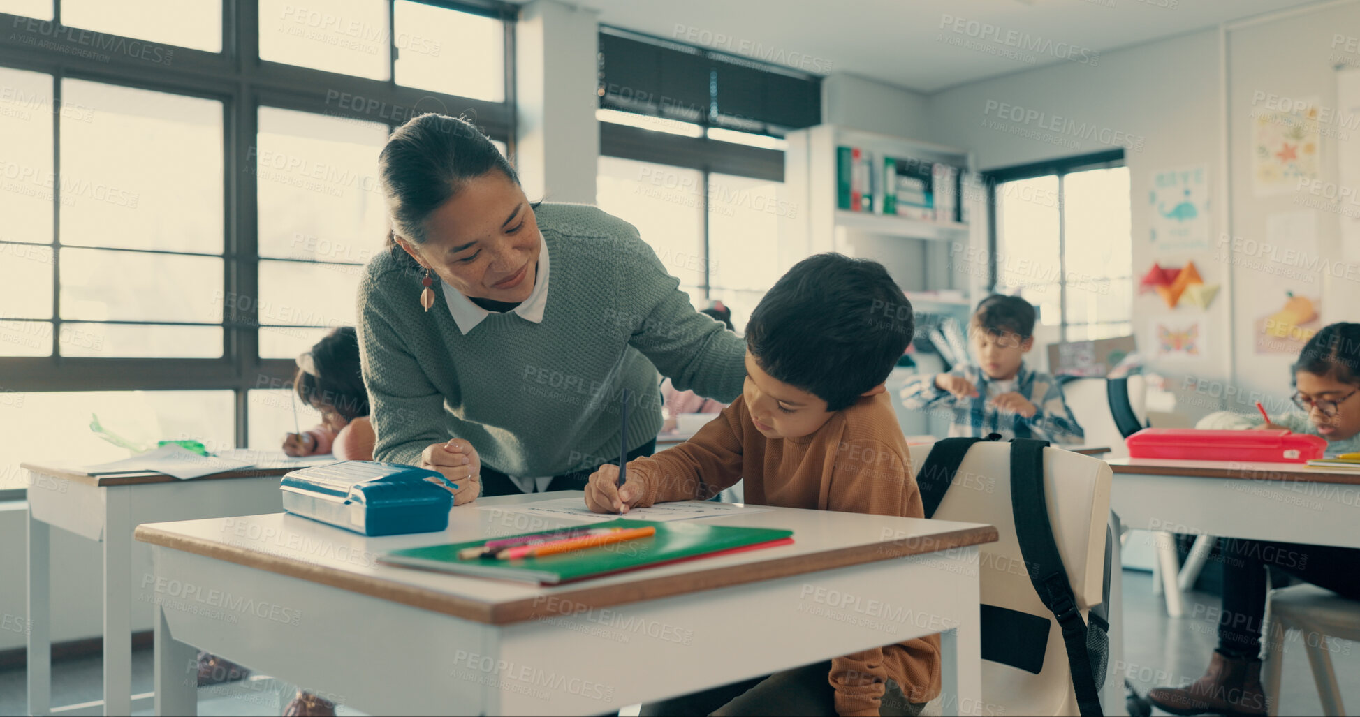 Buy stock photo Help, teacher and student in classroom with notebook, growth and child development in education. Learning, woman and boy at desk together with support, writing and exam notes at elementary school