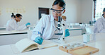 Writing, girl and microscope in science classroom for chemistry analysis, sample study and practical lesson notes. High school, student or results of medical research for education with safety in lab