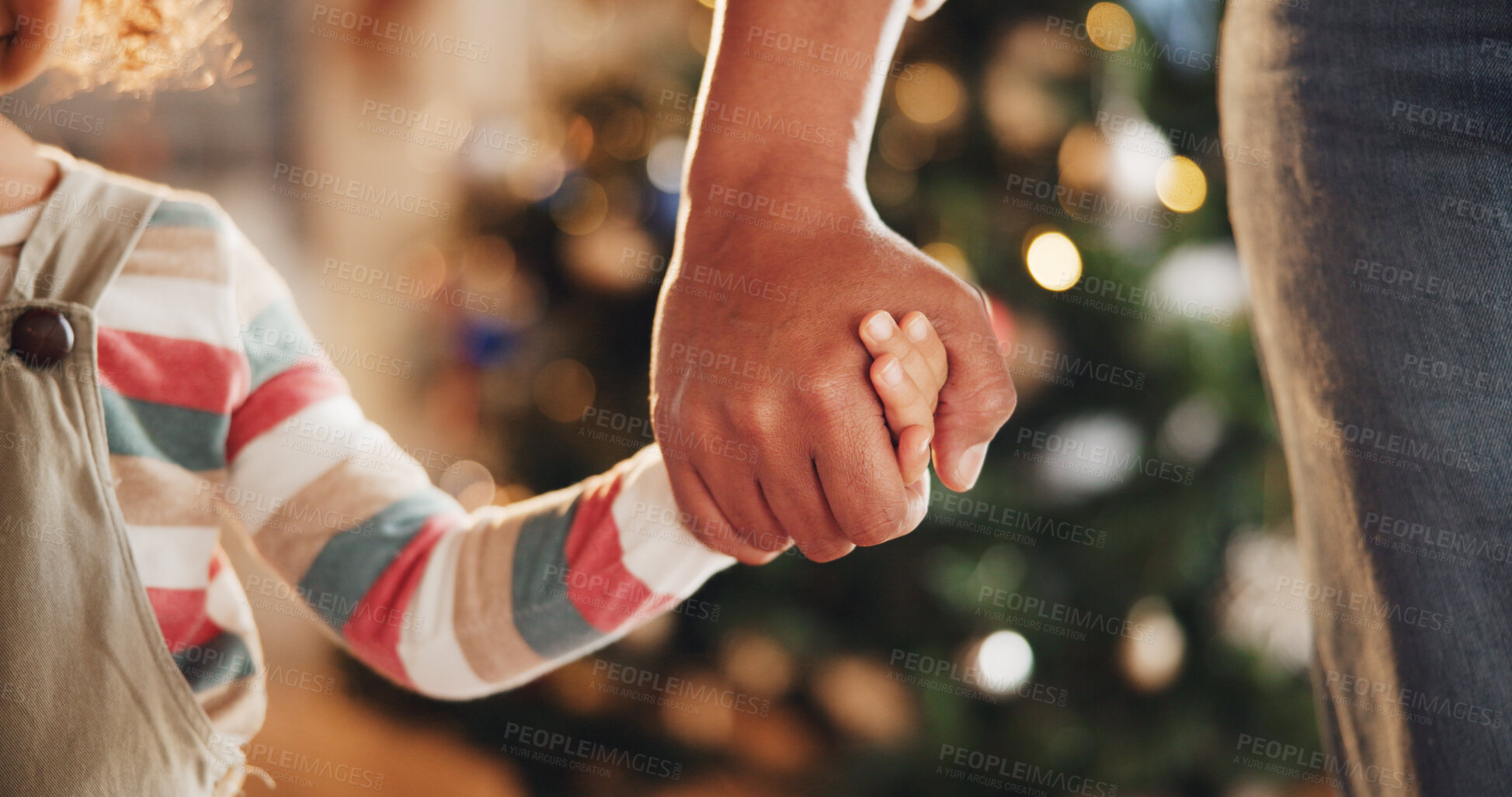 Buy stock photo Christmas, holding hands and parents with kid in home for holiday, vacation and festive season. Family, love and closeup of child for celebration, party and tradition with decoration in living room