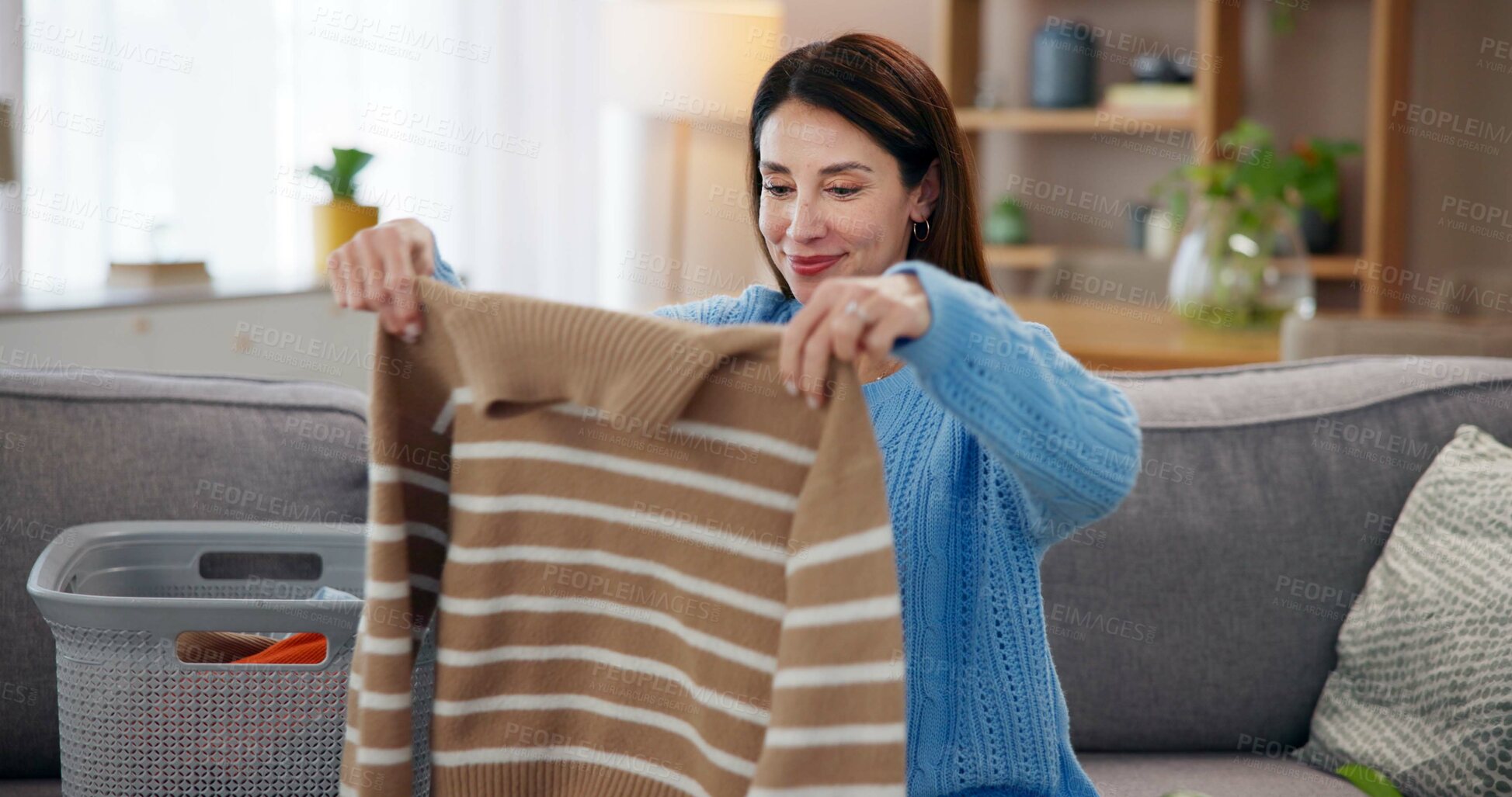 Buy stock photo Laundry, housework and woman on sofa with smile, washing basket and home management in living room. Housekeeping, chores and happy housewife on couch folding fresh clothes, cleaning and morning care