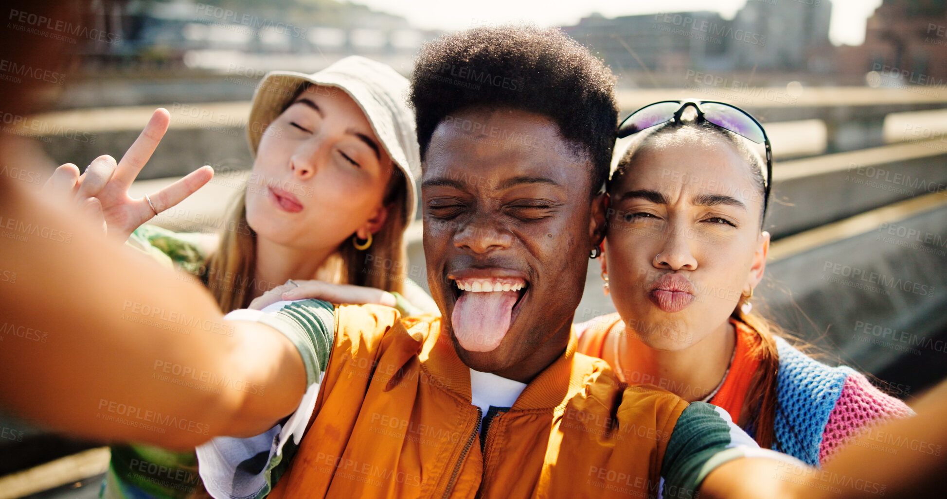 Buy stock photo City, people and friends with tongue out for selfie, summer memory and profile picture for social media. Bridge, women and man with photography for gen z fashion, funny pout or peace sign for bonding