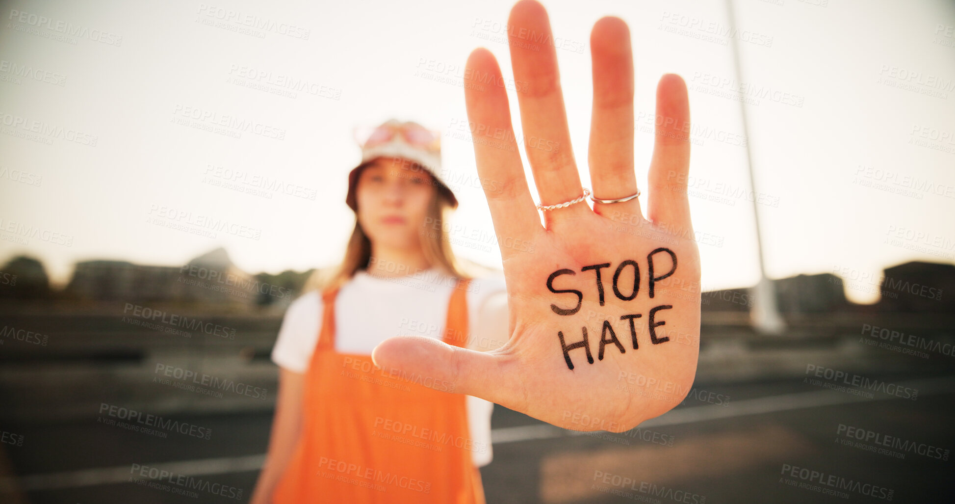 Buy stock photo Hands, stop hate and equality for person with writing, sign and protest for racism, peace and inclusion. Woman, palm and outdoor for activism, accountability and human rights on bridge in Germany