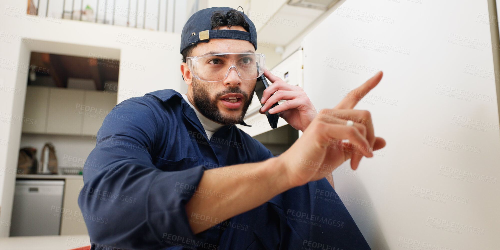 Buy stock photo Plumber, worker and man with phone call in home for pipeline problem, broken sewer and leakage maintenance. Plumbing contractor, handyman and contact owner for filter system installation in kitchen