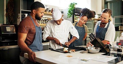 Buy stock photo Cooking, class and chef teaching people in kitchen for knife skills, cutting technique and learning. Culinary course, students and mentor with lesson on onion preparation and education in hospitality