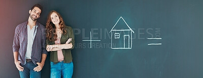 Buy stock photo Shot of a young couple standing in front of a blackboard with symbols written on it