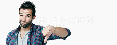 Buy stock photo Studio shot of a young man showing thumbs down against a white background