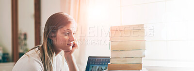 Buy stock photo Shot of a young woman looking overwhelmed by the pile of books on her desk