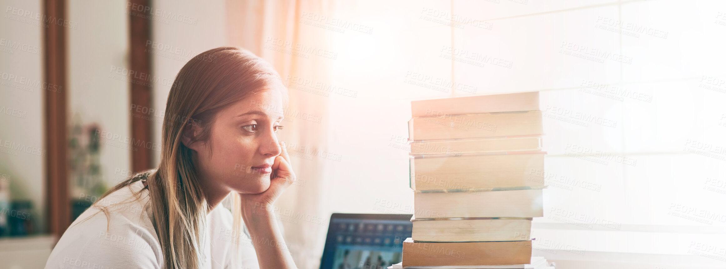 Buy stock photo Shot of a young woman looking overwhelmed by the pile of books on her desk