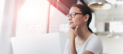 Buy stock photo Shot of a young woman working on a laptop in an office