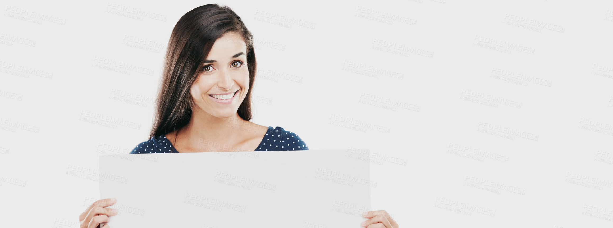 Buy stock photo Studio portrait of an attractive young woman holding a blank placard against a white background